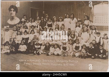 Frau W.A. Roelichs Jugendliche tanzende Schüler, Party in Kostüminstanz, 31. Januar 1920: Gruppenfoto von Kindern in Kostüminstanz mit Innenaufnahme ihres Lehrers Stockfoto