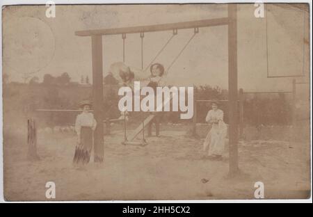 Edwardianische Damen, die auf den Schaukeln auf einem Spielplatz oder Park spielen, um 1909 Stockfoto