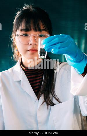 Junger Wissenschaftler experimentiert mit flüssiger Lösung im Labor Stockfoto
