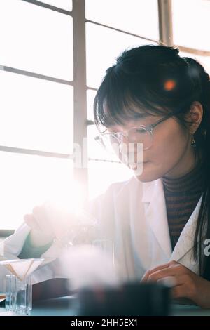 Junger Chemiker, der im Labor wissenschaftliche Experimente macht Stockfoto