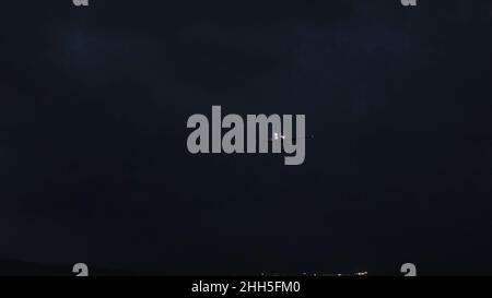 Nachtlandschaft. Aufnahme. Passagierflugzeug über Nacht Meer. Das Flugzeug landet nachts über dem Meer. Stockfoto