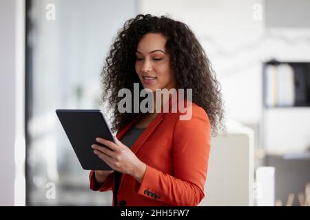 Geschäftsfrau, die am Arbeitsplatz einen Tablet-PC verwendet Stockfoto