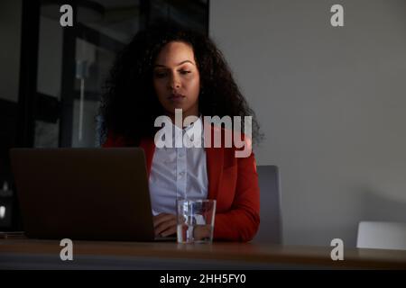 Geschäftsfrau, die am Arbeitsplatz an einem Laptop arbeitet Stockfoto