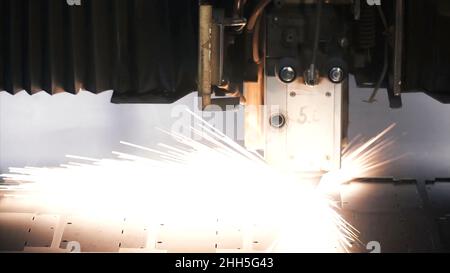 Lasermaschine Schneiden von Blech. Clip. Funken fliegen vom Laser durch automatisches Schneiden CNC, SPS-Maschine. Stockfoto