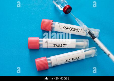 Injektions- und Abstrichtuben mit medizinischen Proben auf blauem Hintergrund Stockfoto