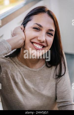Schöne lächelnde junge Frau mit schwarzen Haaren Stockfoto