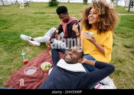 Frau, die mit Freunden im Park beim Picknick zu Mittag gegessen hat Stockfoto