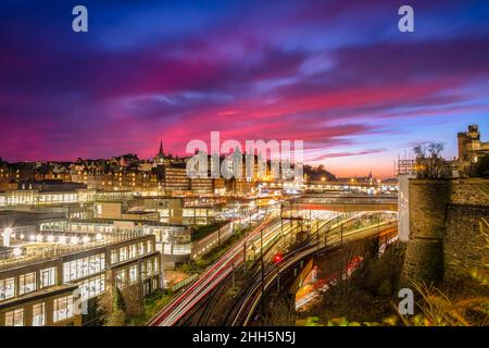 Großbritannien, Schottland, Edinburgh, lange Exposition von lila Wolken über Edinburgh Waverley Bahnhof in der Dämmerung Stockfoto