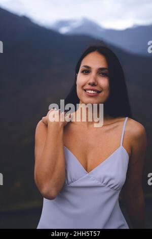 Schöne lächelnde junge Frau in lila Kleid Stockfoto