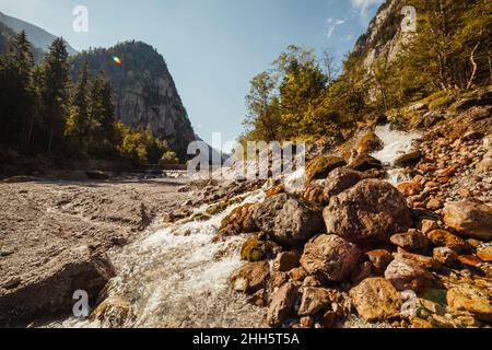 Alpenbach fließt zwischen Felsen Stockfoto