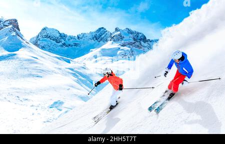 Mann und Frau beim Skifahren auf dem schneebedeckten Berg in Lech, Österreich Stockfoto