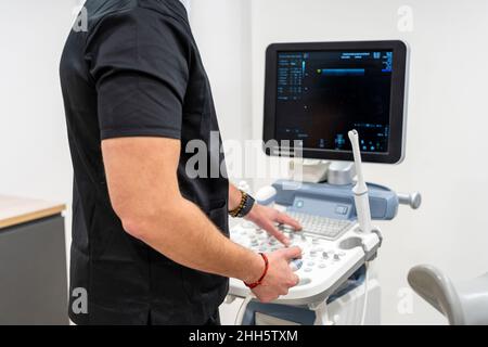 Gynäkologe, der an einem medizinischen Scanner in der Klinik arbeitet Stockfoto