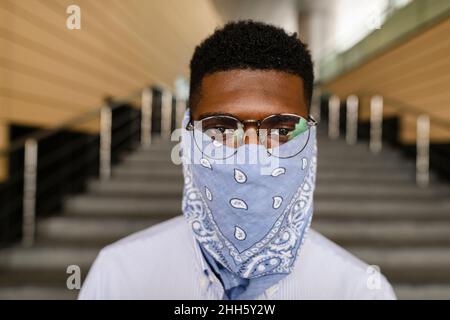 Mann mit Brille und Bandana-Gesichtsmaske Stockfoto