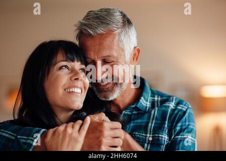 Lächelnde paar umarmen zu Hause Stockfoto