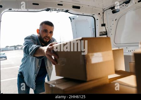 Der Lieferer arrangierte Boxen im Lieferwagen Stockfoto