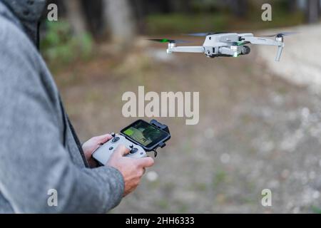 Pilot-Drohne fliegt durch Funk-Handset im Park Stockfoto