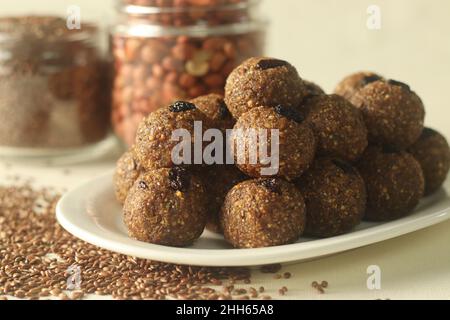 Leinsamen Erdnuss Laddu. Indische Süßigkeit, hergestellt aus grob gemahlenen Leinsamen und Erdnüssen mit frisch geriebener Kokosnuss und Jaggery, aromatisiert von Cardamo Stockfoto