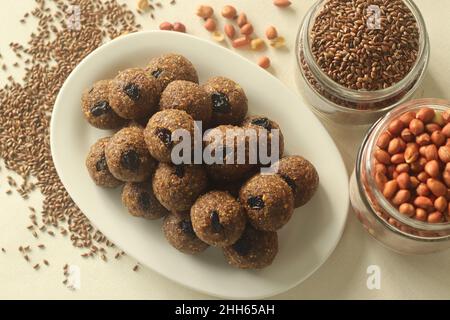 Leinsamen Erdnuss Laddu. Indische Süßigkeit, hergestellt aus grob gemahlenen Leinsamen und Erdnüssen mit frisch geriebener Kokosnuss und Jaggery, aromatisiert von Cardamo Stockfoto