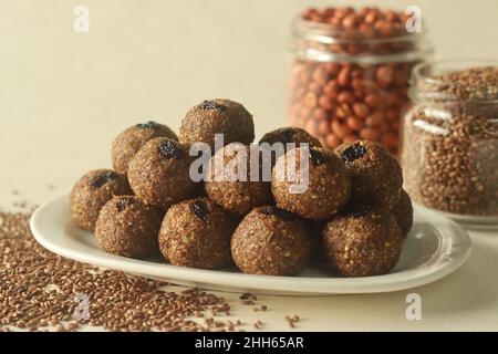 Leinsamen Erdnuss Laddu. Indische Süßigkeit, hergestellt aus grob gemahlenen Leinsamen und Erdnüssen mit frisch geriebener Kokosnuss und Jaggery, aromatisiert von Cardamo Stockfoto