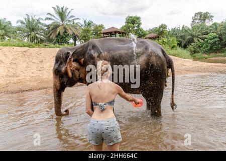 Frau, die im Fluss einen Elefanten badete Stockfoto