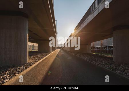 Deutschland, Brandenburg, Schönefeld, Sonne untergeht auf erhöhten Straßen am Flughafen Berlin Brandenburg Stockfoto