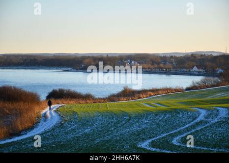 Blick von den Klippen bei Sonnenuntergang auf die Strandstadt Boltenhagen an einem frostigen, schneereichen Wintertag, Mecklenburg, Deutschland Stockfoto