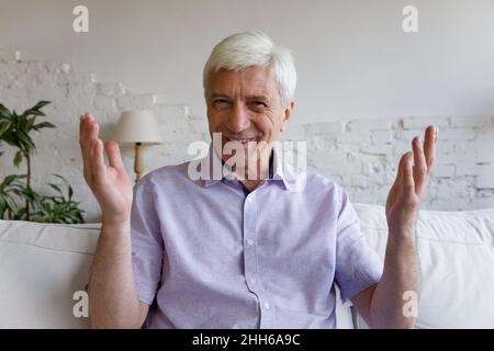 Fröhlicher Mann, der beim Videoanruf die Kamera anspricht und lächelt Stockfoto