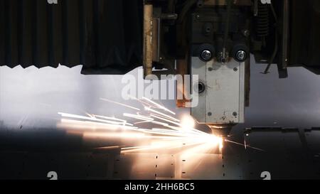 Lasermaschine Schneiden von Blech. Clip. Funken fliegen vom Laser durch automatisches Schneiden CNC, SPS-Maschine. Stockfoto