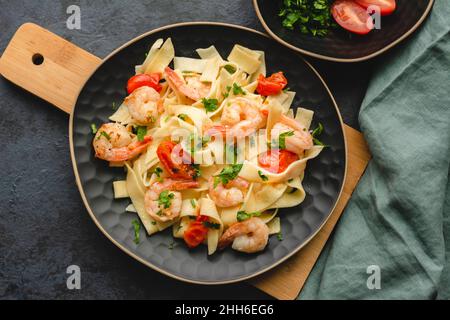 Pasta mit Garnelen in einer Knoblauchsauce mit Butter, Petersilie und Kirschtomate. Stockfoto