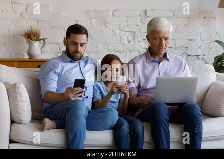 Digital süchtig drei männliche Familiengenerationen mit Geräten zu Hause Stockfoto