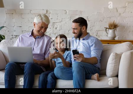 Glückliches Kind, Vater, Großvater mit digitalen Gadgets zu Hause Stockfoto