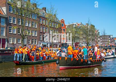 AMSTERDAM, NIEDERLANDE - 27. April 2019: Niederländische Bürger feiern den Königstag auf den Kanälen von Amsterdam in den Niederlanden Stockfoto