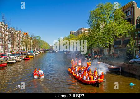 AMSTERDAM, NIEDERLANDE - 27. April 2019: Niederländische Bürger feiern den Königstag auf den Kanälen von Amsterdam in den Niederlanden Stockfoto