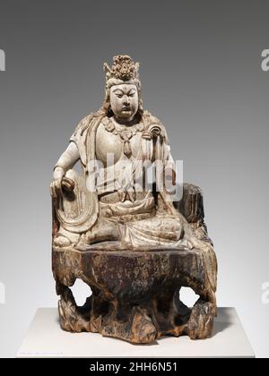Bodhisattva Avalokiteshvara in Wassermondform (Shuiyue Guanyin) aus dem Jahr 1385 China Diese mächtige Figur gehört zu einer kleinen Gruppe von Holzskulpturen, die sicher datiert werden können, dank einer Inschrift, die auch seltene Informationen über ihre Herstellung und ihren Verwendungszweck liefert. Die Inschrift erscheint auf der Innenfläche einer abnehmbaren Tafel auf der Rückseite der Figur, die Zugang zu einer Kammer bietet, die einst Konsekratorium enthielt. Sie besagt, dass die Skulptur 1385 unter der Leitung eines bestimmten Xin Zhongwen geschnitzt wurde, der zusammen mit Mitgliedern des Dorfes Dongan Th in Auftrag gab Stockfoto