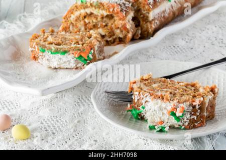 Eine Portion Karottenkuchengelee Rolle mit einer Platte des gleichen in hinten. Stockfoto