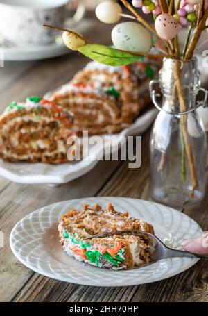 Karottenkuchengelee Rollen zu Ostern, mit einer Scheibe auf einem Teller davor. Stockfoto