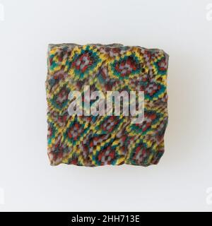 Inlay-Fragment, Netzmuster mit Zentren 100 v. Chr.–100 n. Chr. Ptolemäische Periode–Römische Periode Eine Mosaikglas-Technik ermöglichte die Schaffung von Vielfachen eines Bildes: Eine figürliche oder gestalterische Komposition wurde durch Bündelung von farbigen Glasstöcken hergestellt, die dann zu einem langen Balken herausgezogen wurden. Die Stange wurde dann im rechten Winkel geschnitten, wahrscheinlich durch Aufschlagen der Stange mit geeigneten Werkzeugen, um kleine Inlay-Fliesen zu produzieren. Die Fliese würde dann geglättet und auf dem Gesicht poliert, das nach außen erscheinen soll. Inlay-Fragment, Netzwerkmuster mit Zentren. 100 V. CHR.–100 N. CHR. Glas. Ptolemäische Periode–Römische Periode. Aus Ägypten Stockfoto