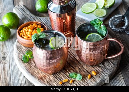 Moscow Mule Cocktails mit Minze und Limette garniert und mit Erdnüssen serviert. Stockfoto
