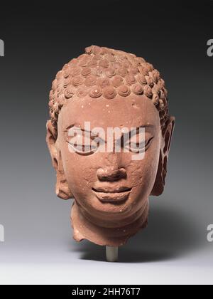 Kopf eines Buddhas Ende des 5th.–Anfang des 6th. Jahrhunderts Indien (Uttar Pradesh, Mathura) dieser Kopf aus einer fast lebensgroßen Figur des Buddha spiegelt die späte Gupta-künstlerische Sprache wider. In dem Bemühen, Buddhas Erleuchtung und seine nach innen gerichtete meditative Natur darzustellen, abstrahierte und idealisierte der Künstler seine physischen Merkmale, besonders deutlich in der Artikulation der Augen und den sich kreuzenden konvexen Ebenen seiner Wangen und Stirn. Kopf eines Buddha. Indien (Uttar Pradesh, Mathura). Ende 5th bis Anfang 6th Jahrhundert. Roter Sandstein. Späte Gupta-Periode. Skulptur Stockfoto