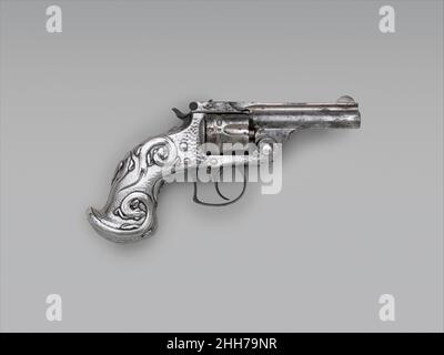 Smith und Wesson .38 Kaliber Double-Action Revolver, Seriennr 70002 1882–83 Smith & Wesson American der silberne Griff hat eine gehämmerte Oberfläche, die bei inländischen Silberbesteck der Zeit beliebt ist. Das Design spiegelt den eleganten, skurrilen Stil des Jugendstils wider. Das ursprüngliche Design für den Griff, datiert 1883, ist im Tiffany-Archiv erhalten. Smith und Wesson .38 Kaliber Double-Action Revolver, Seriennr 70002. Amerikaner, Springfield, Massachusetts und New York. 1882–83. Stahl, Nickel, Silber. Springfield, Massachusetts; New York, New York. Schusswaffen-Pistolen-Revolver Stockfoto