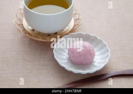 sakura Mochi Reiskuchen mit heißem Tee auf Tischtuch Stockfoto