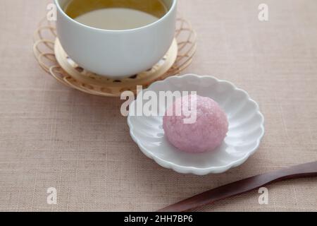 sakura Mochi Reiskuchen mit heißem Tee auf Tischtuch Stockfoto