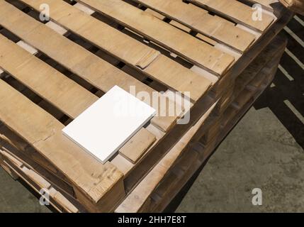 Unbeschriftete Buchmockup auf Holzpaletten, Notebook-Mockup, Mockup Natur Stockfoto