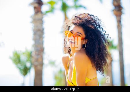 Multikulturelle Frau mit langen Afro-Locken am Sommertag fühlt sich kraftvoll und furchtlos Stockfoto