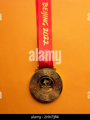 6. Januar 2021, Peking China. Goldmedaille der XXIV. Olympischen Winterspiele auf orangefarbenem Hintergrund. Stockfoto