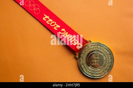 6. Januar 2021, Peking China. Goldmedaille der XXIV. Olympischen Winterspiele auf orangefarbenem Hintergrund. Stockfoto