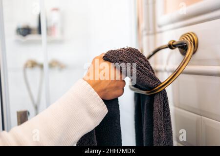Hände einer Frau, die mit einem Handtuch greift, um ihre Hände zu trocknen Stockfoto