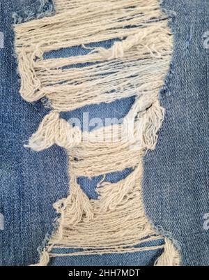 Nahaufnahme von blauem Denim-Stoff mit ausgefransten Fäden Stockfoto