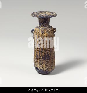 Glas-Alabastron (Parfümflasche) Mitte 4th–Anfang 3rd Jahrhundert v. Chr. Griechisch, östliches Mittelmeer oder Italienisch Durchscheinendes Kobaltblau, mit Griffen in gleicher Farbe; Spur in unsicherer Farbe (opakes Weiß ?).breite horizontale Randscheibe, leicht nach außen abfallend; hoher zylindrischer Hals; schmale horizontale Schulter; gerader zylindrischer Körper, Mit nach oben geknallter Form; konvexer Boden; unter der Schulter zwei vertikale Ringgriffe, beide durchbohrt, mit kurzen spitzen Trails, über dem Trailmuster angebracht.Ein einzelner feiner Trail, der um den Körper gewickelt ist, von oben nach unten zu einem eng angesetzten Zickzack-Muster in zehn Versen geschwenkt Stockfoto