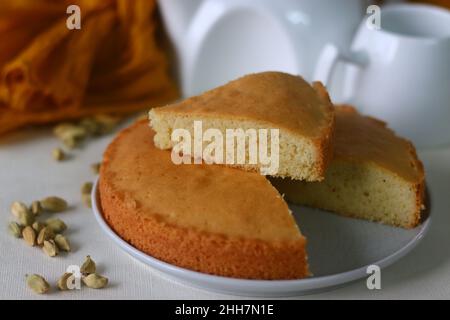 Scheibe Ghee-Kuchen. Eine Version von Teekuchen mit Ghee und Kardamom gewürzt. Perfekt zu einer Tasse heißen Tee. Aufgenommen auf weißem Hintergrund. Stockfoto